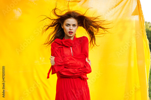 emotional woman in red dress nature yellow background posing
