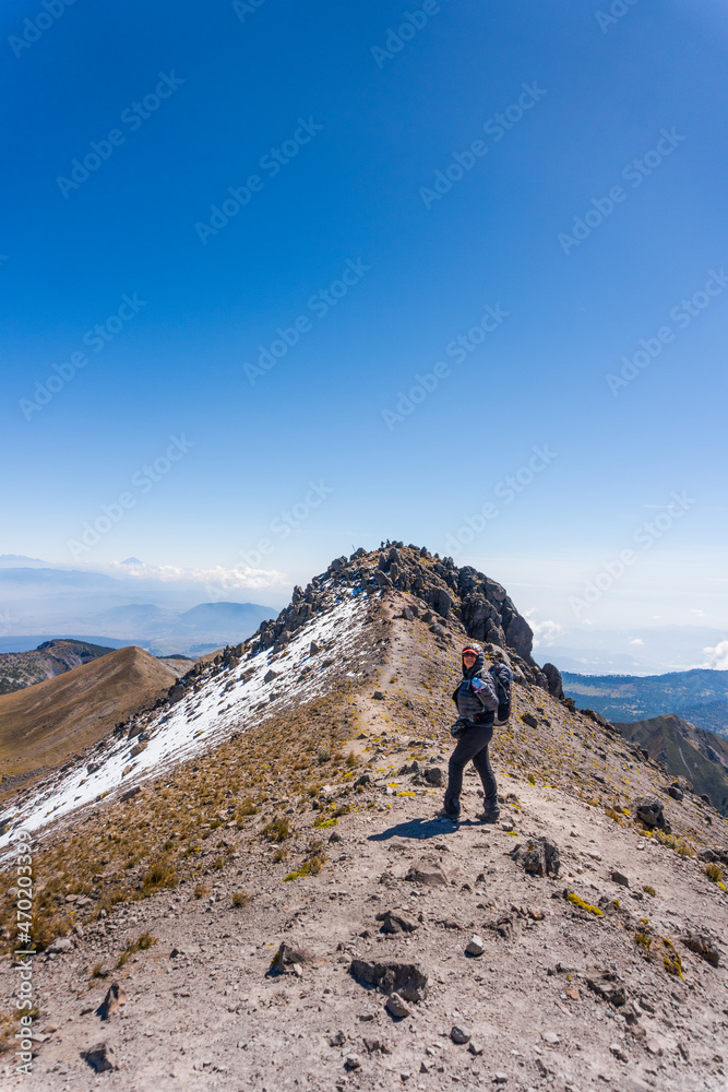 Hiker with backpack relaxing on top of a mountain