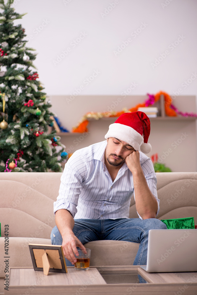 Fototapeta premium Young man celebrating Christmas at home alone