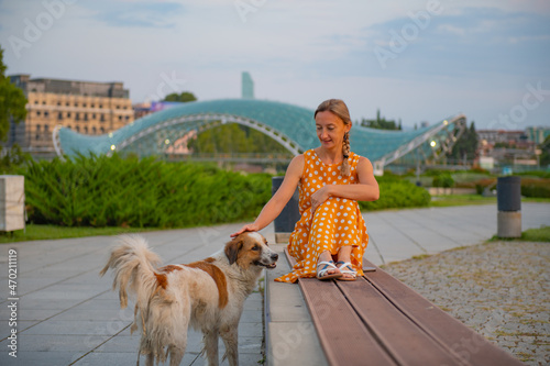girl sitting on a bench with a dog in tbilisi