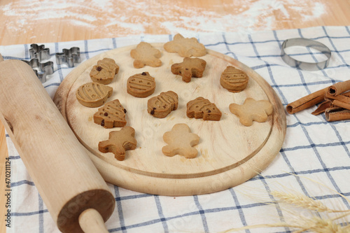 Homemade Christmas ginger bread cookies, Xmas gingerbread cookie on wooden tray with rolling pin, preparing bakery, process of baking and cooking at home.