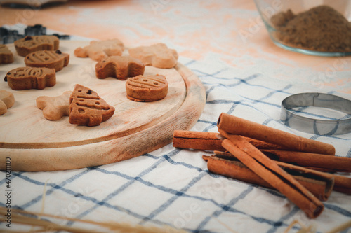 Homemade Christmas ginger bread cookies on wooden try with cinnamon, Xmas gingerbread cookie, preparing bakery, process of baking and cooking at home.