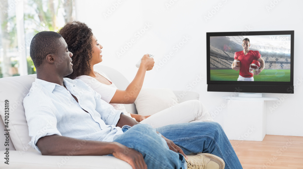 Side view of african american couple sitting at home together watching football match on tv Side view of african american couple sitting at home together watching football match on tv