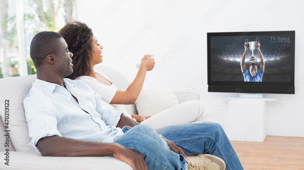 Side view of african american couple sitting at home together watching sport event on tv