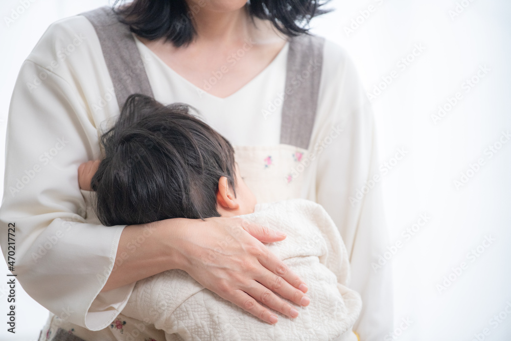 赤ちゃんをリビングで寝かしつける女性 顔無し コピースペースあり 赤ちゃんをリビングで寝かしつける女性 顔無し コピースペースあり
