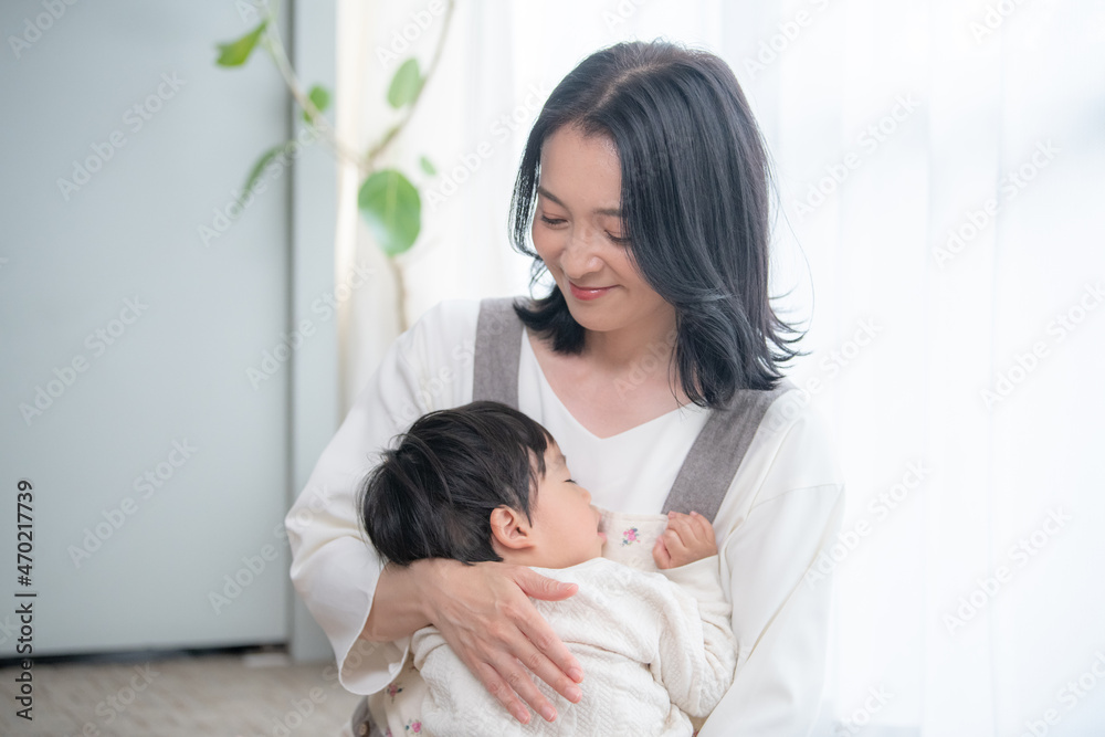 赤ちゃんを白い綺麗な部屋で抱っこする笑顔の美人ママコピースペースあり 赤ちゃんを白い綺麗な部屋で抱っこする笑顔の美人ママコピースペースあり