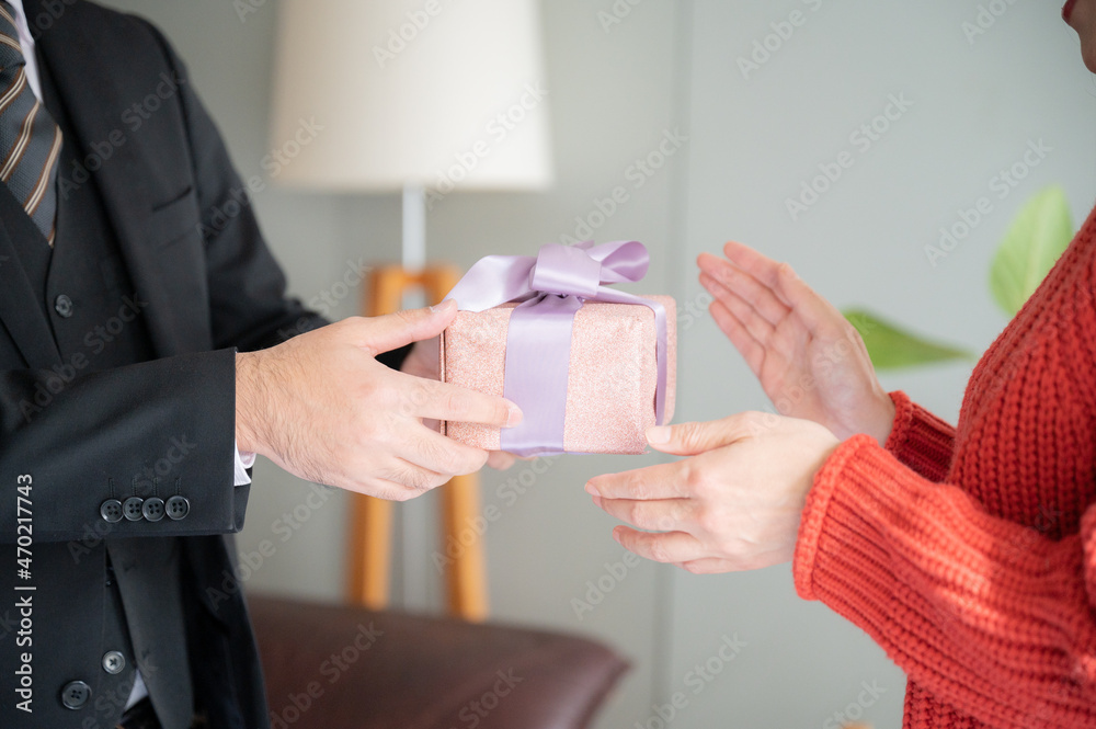 Close-up of the hand in a portrait of a couple giving a gift.