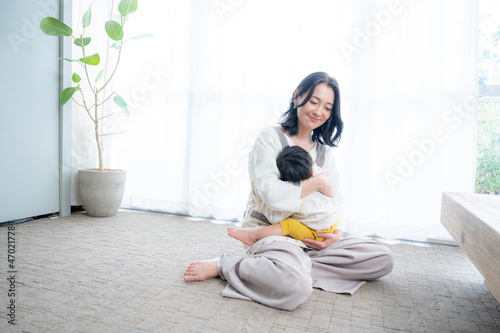 Beautiful smiling mom holding her baby in the living room Zoom Copy Space Wide angle