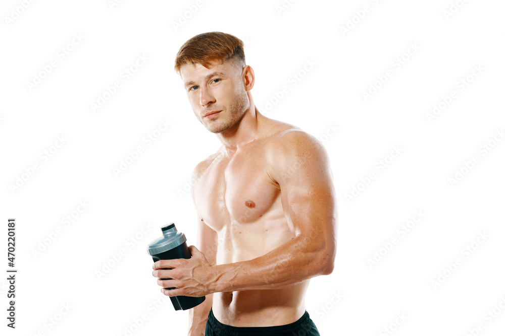 Fototapeta premium a man an athlete with a pumped-up body drinks from a bottle