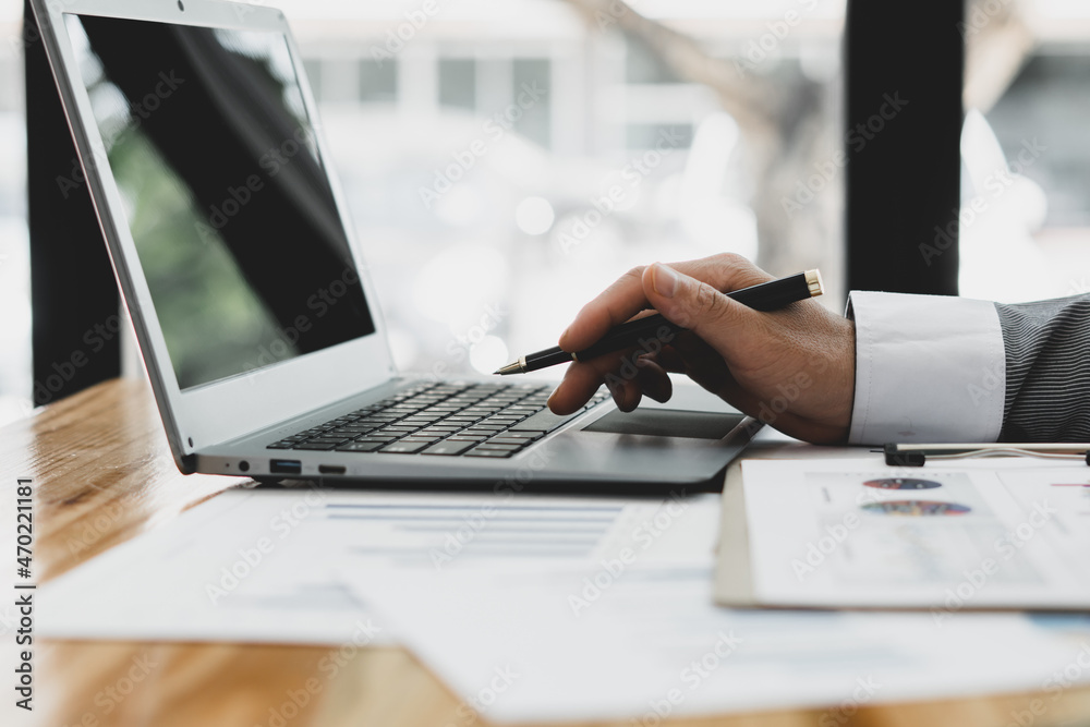 Close up of businessman or accountant working on laptop computer for calculate business data, accounting document and calculator at office, business concept Close up of businessman or accountant working on laptop computer for calculate business data, accounting document and calculator at office, business concept