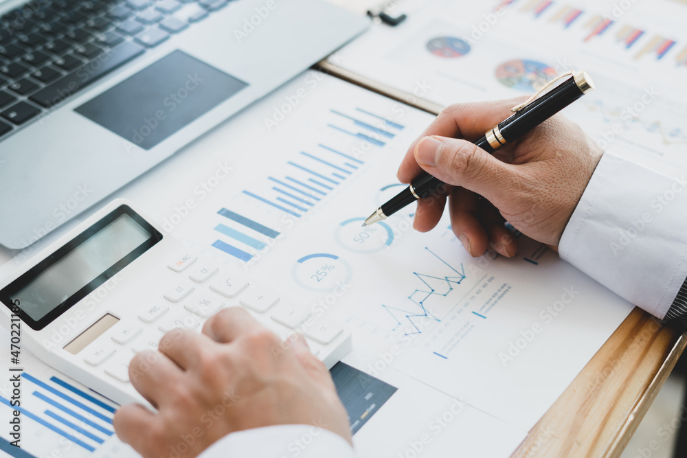Business accounting concept, Business man using calculator with computer laptop, budget and loan paper in office.