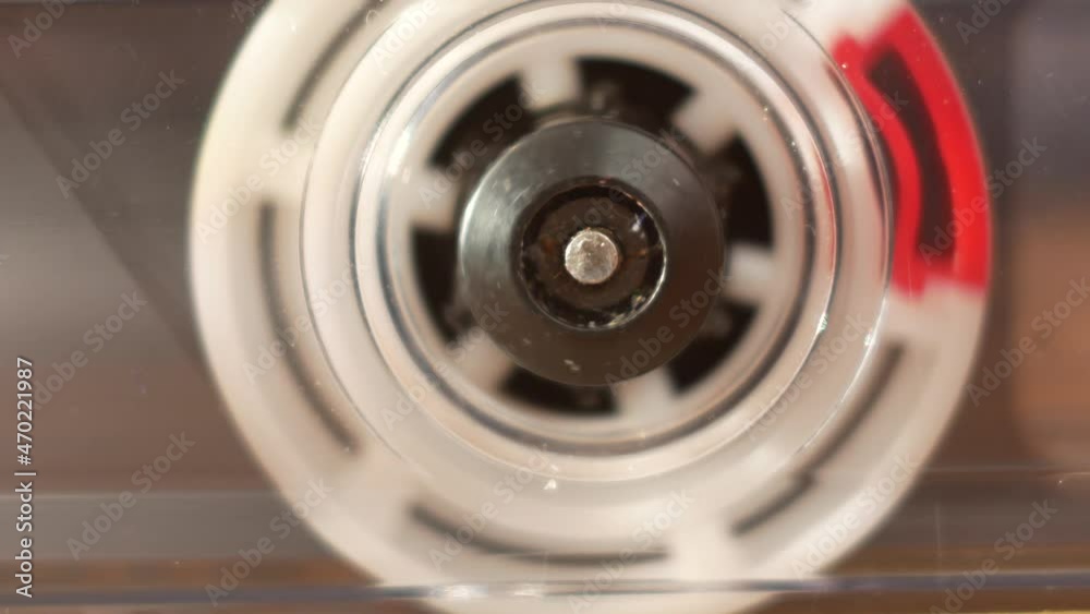 Closeup of a spinning reel of an audio cassette reproducing. The tape