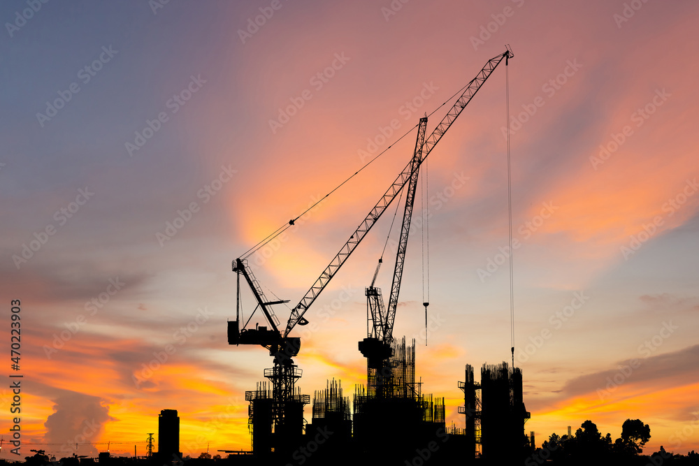 Silhouette of Crane and building construction site sunset sky in evening time