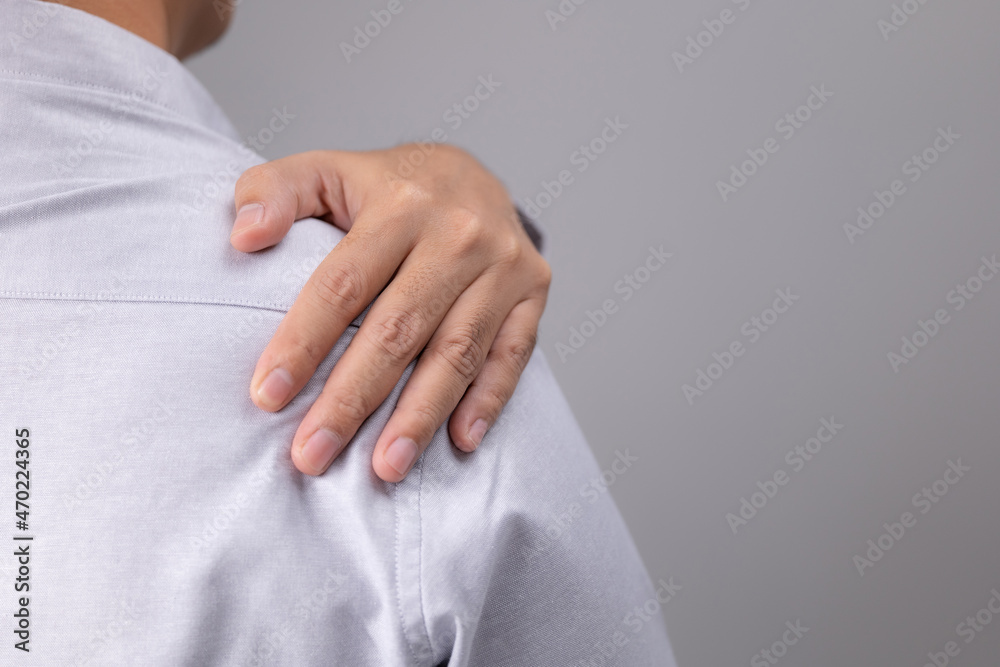 Overworked man with a sprain in his shoulder and muscle soreness. After waking up, a man has a
