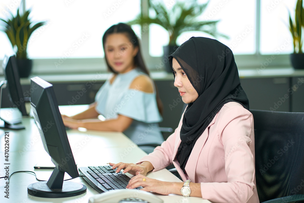 Muslim female with hijab working with friend for business office staff Muslim female with hijab working with friend for business office staff