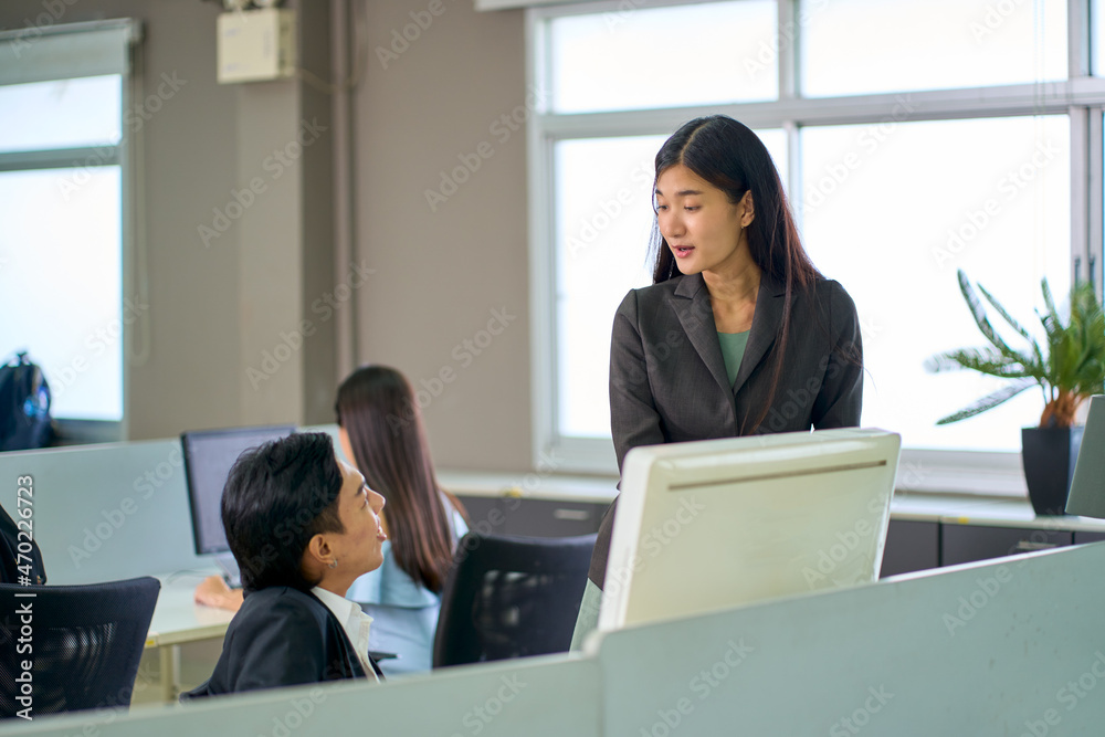 Asian woman manager talking with staff man in business office space