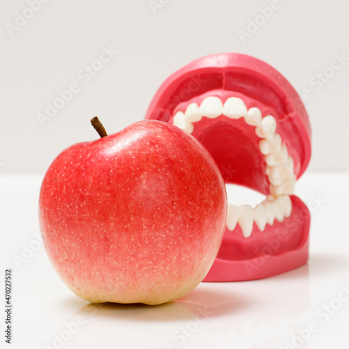 Apple and layout of the human jaw on background.