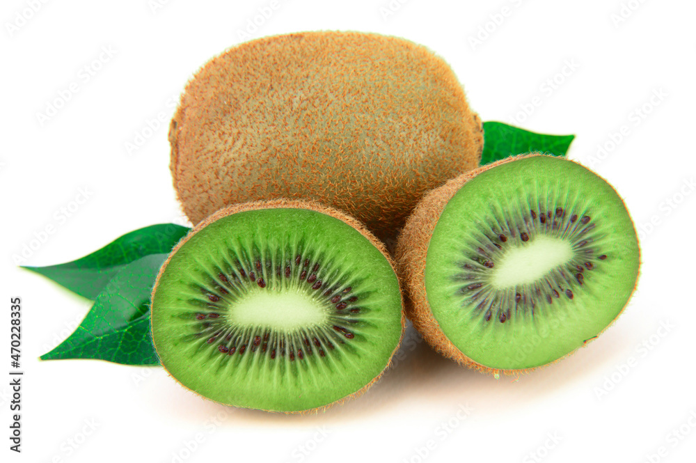 Fototapeta premium A whole kiwi next to another, cut in half. Green leaves lie below