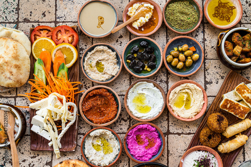 Traditional Turkish Village Breakfast on the ceramic table with pastries, vegetables, greens, spreads, cheeses, fried eggs, jams. Top view