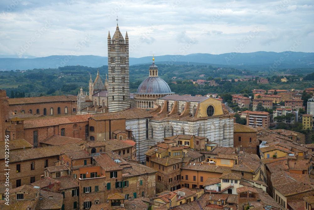 Medieval Cathedral of the Assumption of the Blessed Virgin Mary (Duomo di Siena) in the cityscape on a cloudy September day. Siena, Italy
