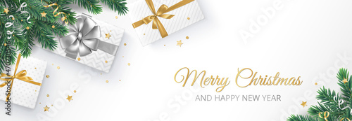 Christmas banner with decorated fir tree branches and presents. Gift boxes with golden and silver ribbons. Merry Christmas text. For New Year and winter holiday cards, headers, gift certificates.