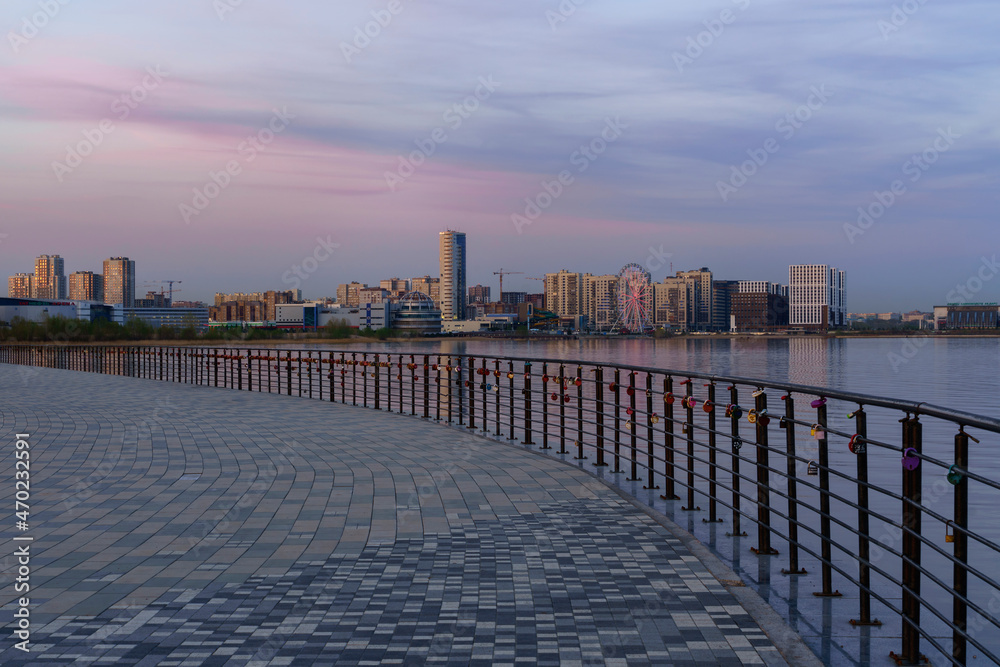 Kazanka River embankment near the family center Kazan against a pink sunset sky, Kazan, Tatarstan, Russia