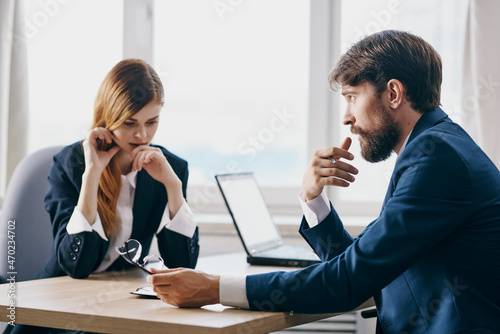 managers sitting at a desk with a laptop communication finance technologies