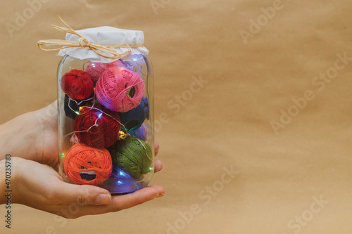 Multicolored threads for embroidery in a jar with lamps in hand