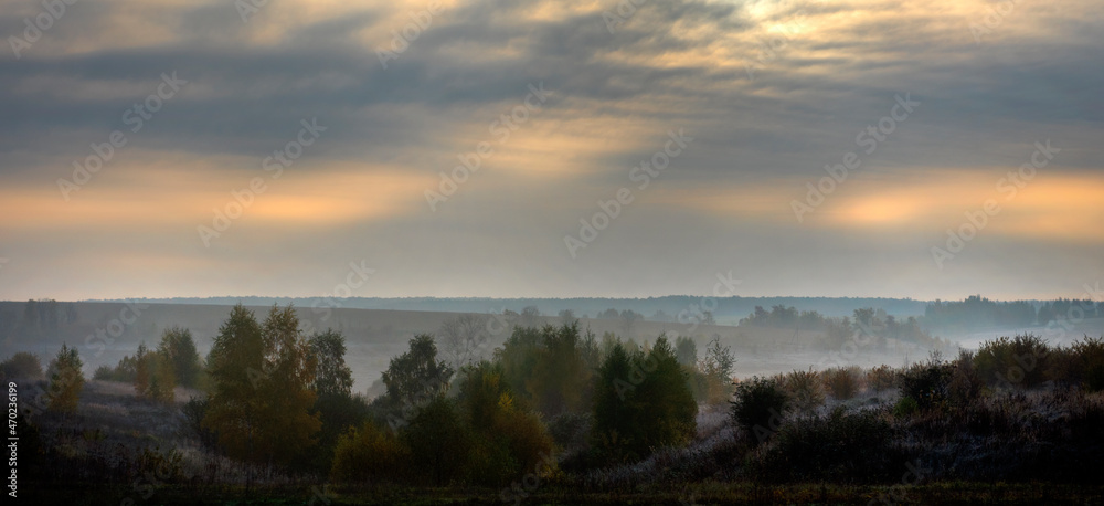 sunrise and morning fog in autumn over a field