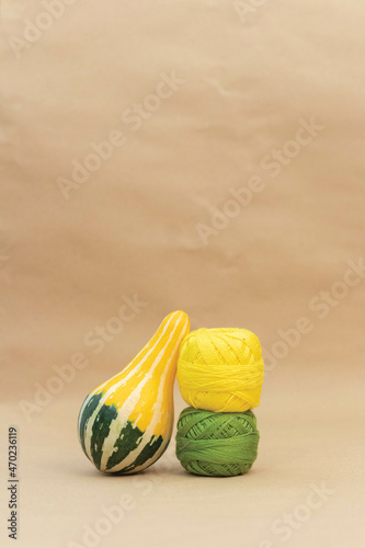 Green and Yellow zucchini on table with leaning against curly green and yellow embroidery thread