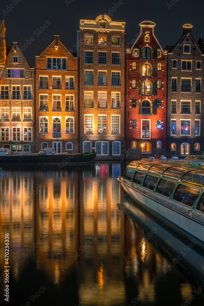 Obraz premium Houses on Water in Night Amsterdam and Pleasure Boat