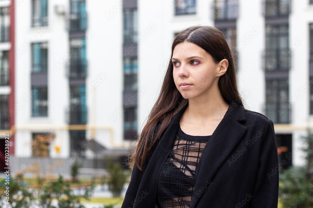 Fototapeta premium Portrait of the young woman in black clothing walking in the city.