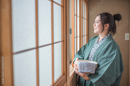 温泉旅行に来て窓の外を眺める女性 