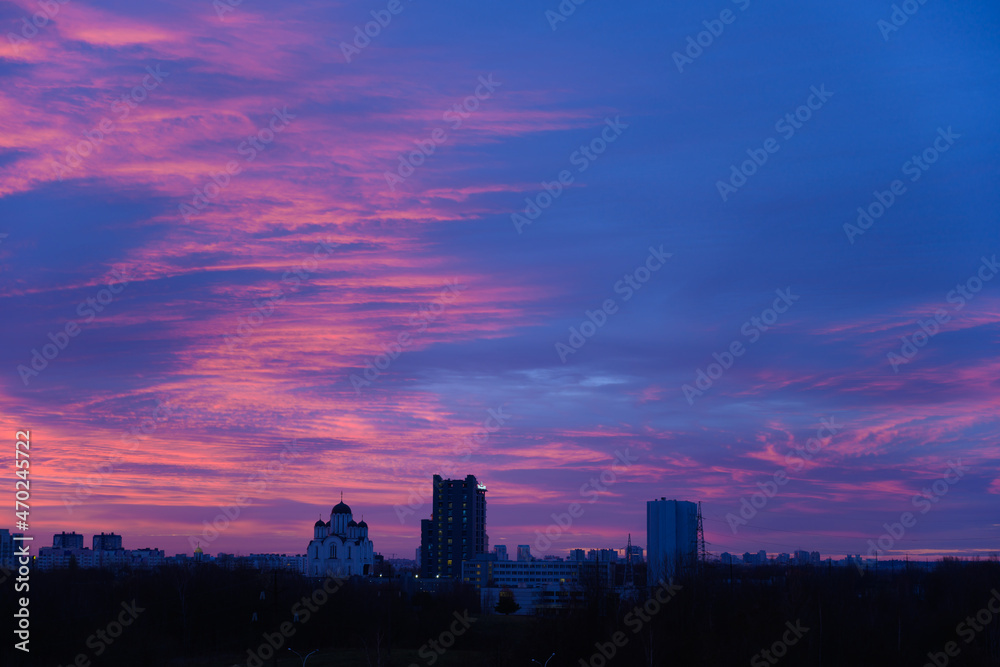 Photo of dark sky with blue red color clouds on city silhouette background Photo of dark sky with blue red color clouds on city silhouette background