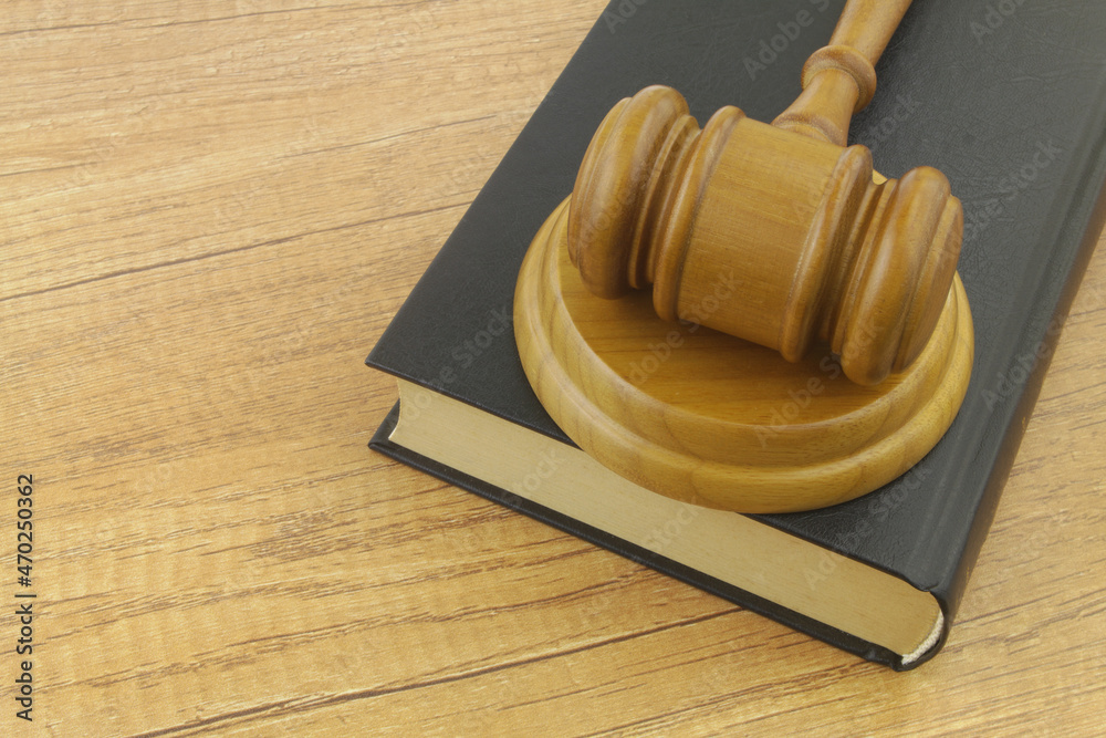 Gavel and legal book on wooden table. Law and justice concept.