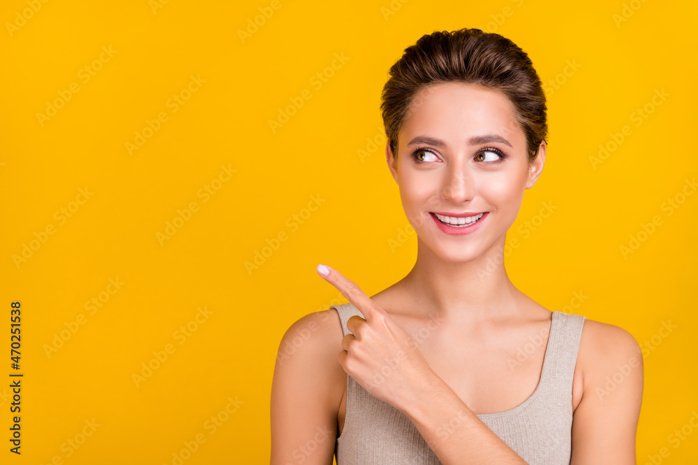 Portrait of attractive shine cheerful girl demonstrating copy empty space ad isolated over bright yellow color background Portrait of attractive shine cheerful girl demonstrating copy empty space ad isolated over bright yellow color background