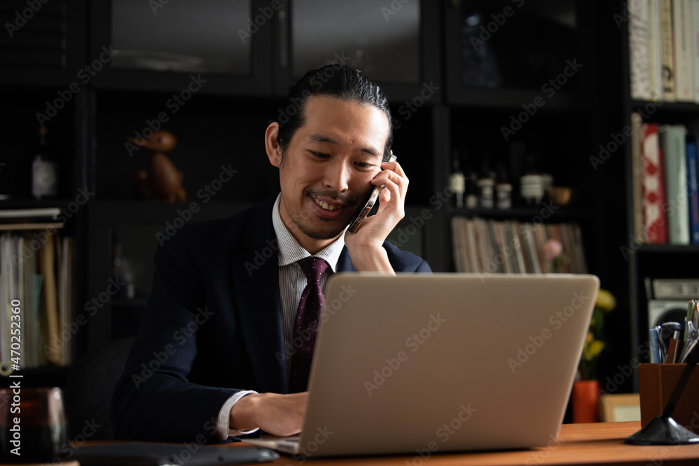 スマホで話すアジア人(日本人)ビジネスマン男性 コピースペースあり スマホで話すアジア人(日本人)ビジネスマン男性 コピースペースあり