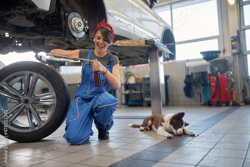 Female mechanic drinks during a break. mechanic female having fun at work