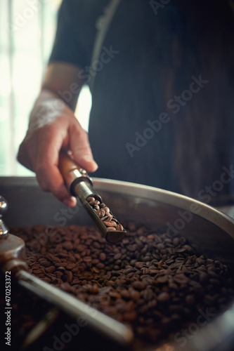 A man is working with a coffee beans grinder. Coffee, beverage, producing