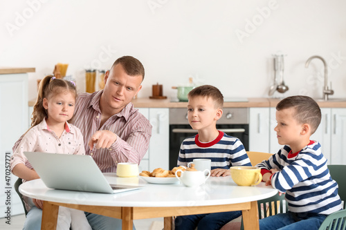 Happy father with his little children spending time together at home