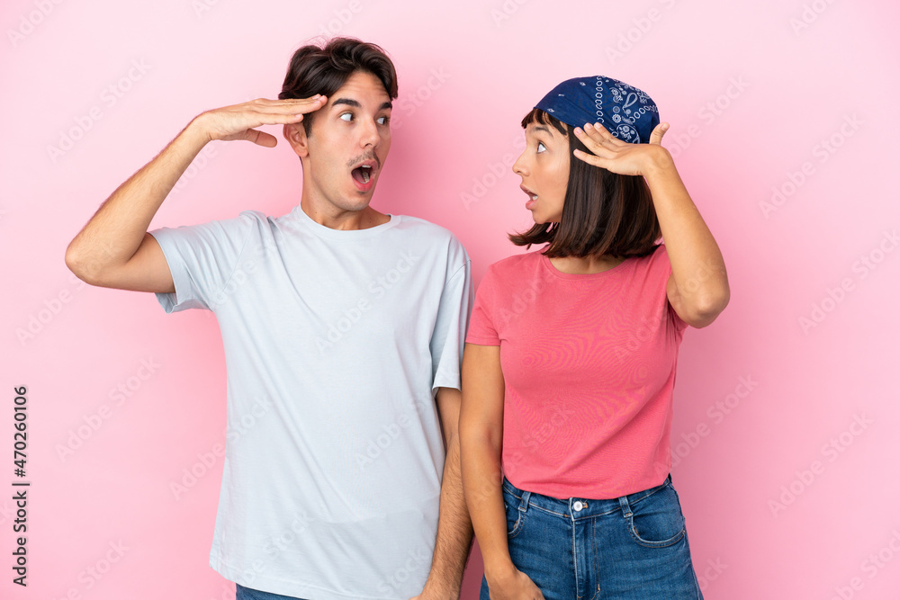 Young couple isolated on pink background with surprise and shocked facial expression Young couple isolated on pink background with surprise and shocked facial expression