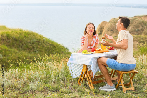Happy young couple having romantic picnic in mountains © Pixel-Shot