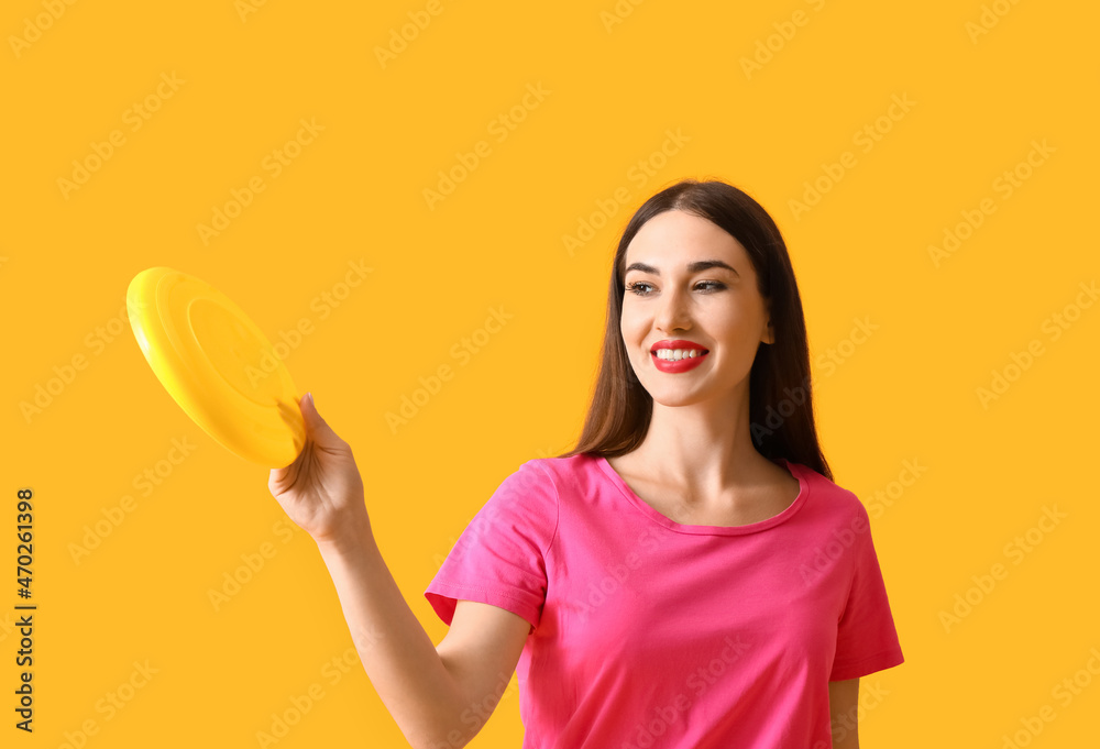 Beautiful young woman playing frisbee on color background Beautiful young woman playing frisbee on color background
