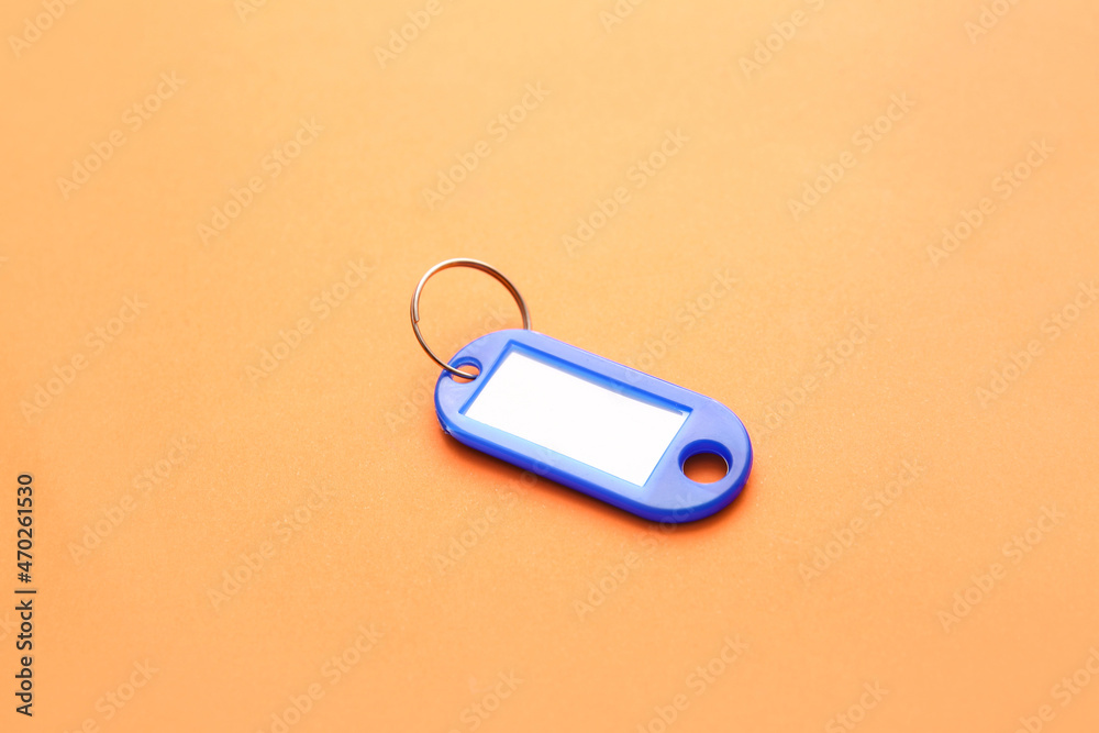 Fototapeta premium Plastic key tag on orange background