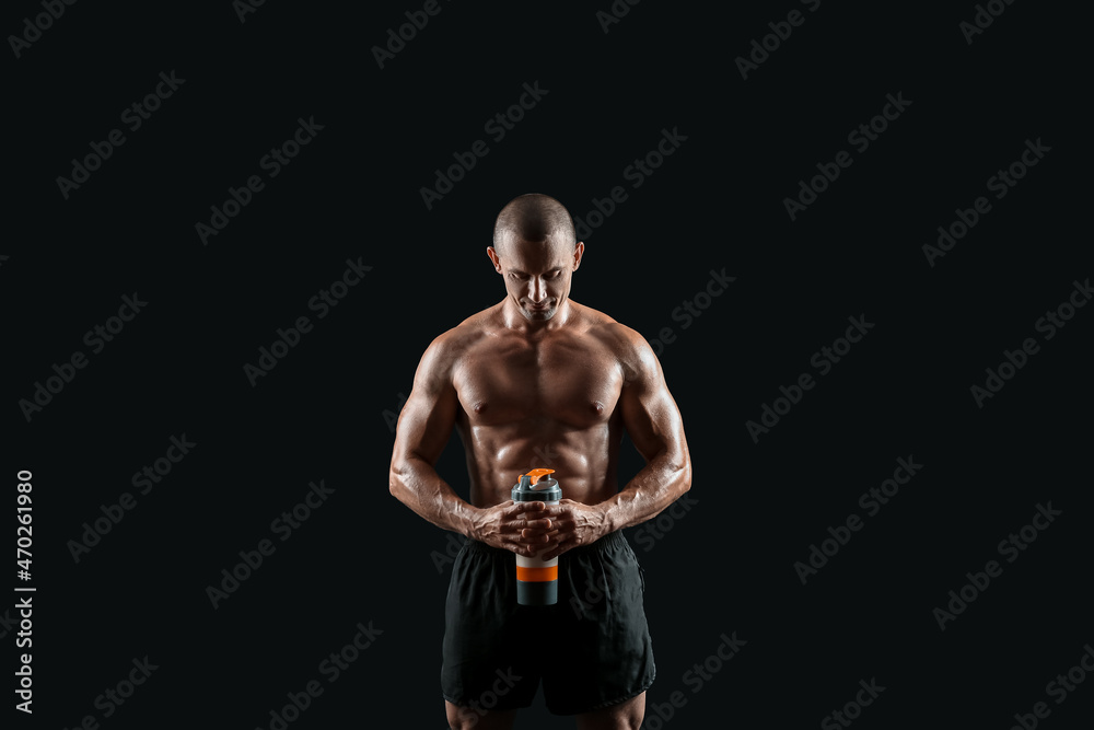 Fototapeta premium Male bodybuilder with protein shake on dark background