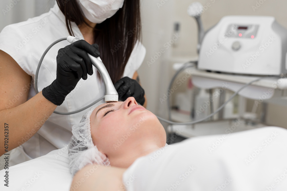 Close-up of the face of a young girl who does no-injection mesotherapy in a modern cosmetology office. The concept of cosmetology and facial skin care Close-up of the face of a young girl who does no-injection mesotherapy in a modern cosmetology office. The concept of cosmetology and facial skin care