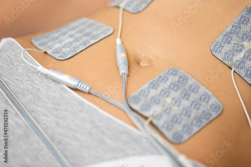 Therapist applying lipomassage on girls body in spa. Close-up of biostimulating apparatus for anti-cellulite lipomassage. Hardware cosmetology photo