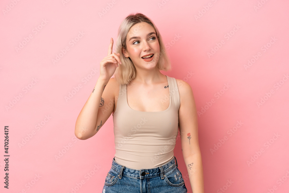 Young caucasian woman isolated on pink background intending to realizes the solution while lifting a finger up Young caucasian woman isolated on pink background intending to realizes the solution while lifting a finger up