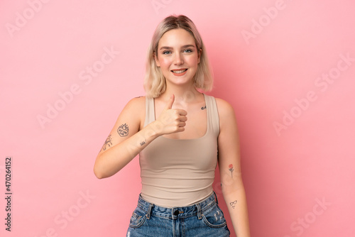 Young caucasian woman isolated on pink background giving a thumbs up gesture © luismolinero