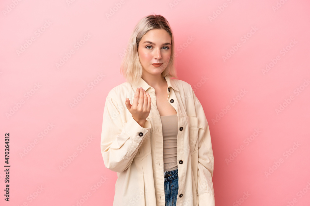 Young caucasian woman isolated on pink background inviting to come with hand. Happy that you came Young caucasian woman isolated on pink background inviting to come with hand. Happy that you came